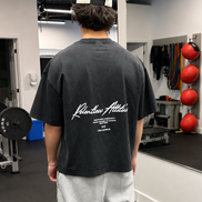 A young muscular man wearing a black washed baggy t-shirt at the gym