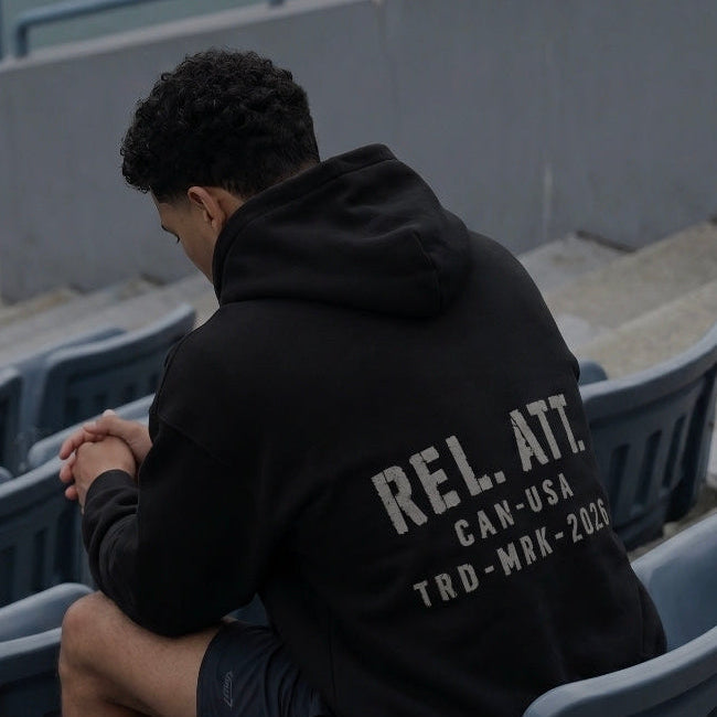 A muscular man wearing the trademark hoodie in a blue sports stadium