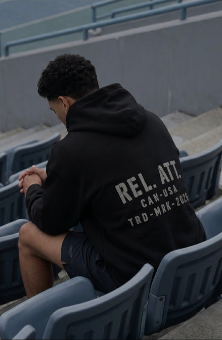 A muscular man wearing the trademark hoodie in a blue sports stadium