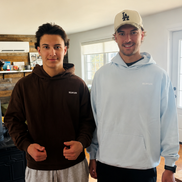 Two men wearing the Standard Relentless Hoodie in a living room